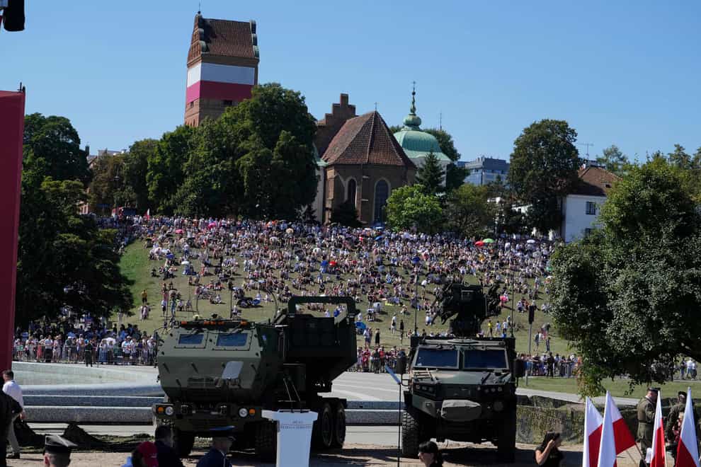 People watch a massive military parade (Czarek Sokolowski/AP)