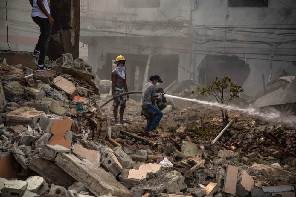 Firefighters put out a fire after a powerful explosion in San Cristobal, Dominican Republic (Jolivel Brito/Diario Libre via AP)