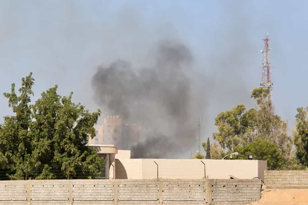 Smoke rises during clashes between rival militias in Tripoli (AP)