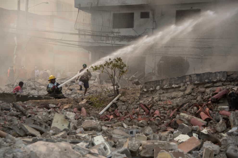 Firefighters put out a fire after a powerful explosion in San Cristobal (Diario Libre via AP)