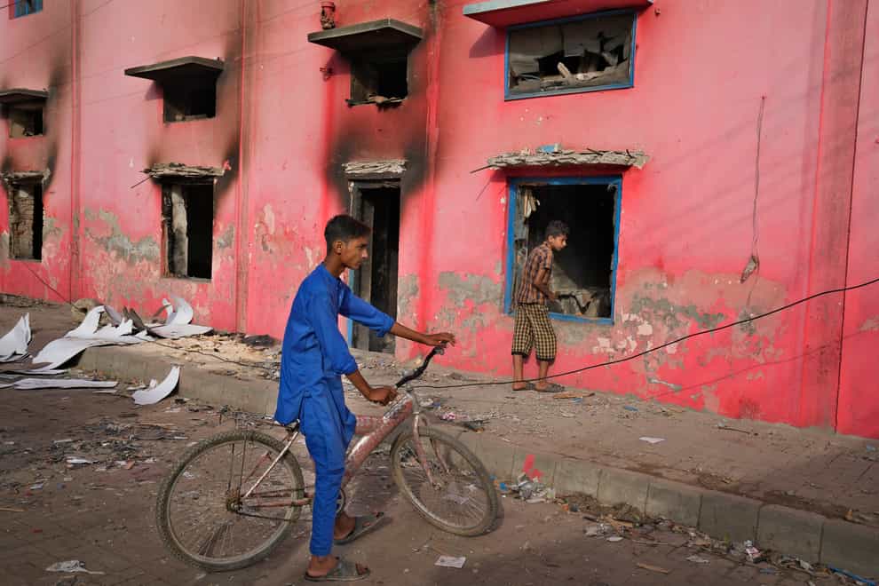 Youngsters look at a church vandalised by an angry Muslim mob in Jaranwala near Faisalabad, Pakistan (K M Chaudary/AP)