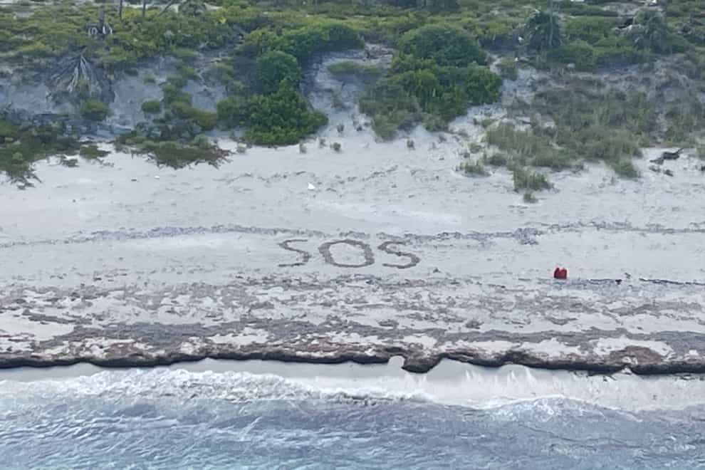 The letters SOS etched in the sand during the Coast Guard’s rescue (U.S. Coast Guard via AP)