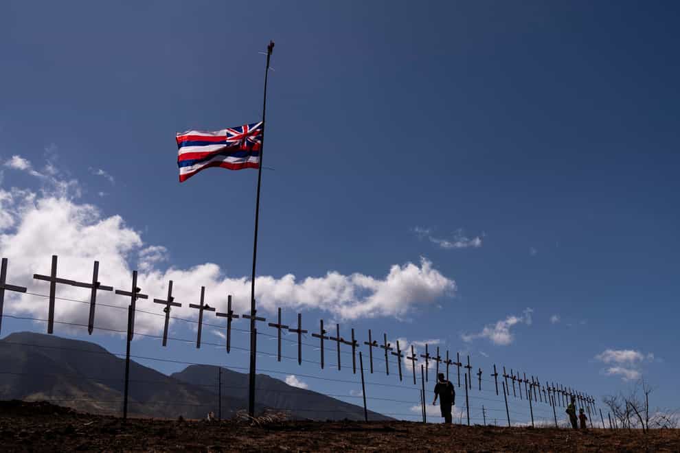 Crosses honouring the victims killed in the wildfire hang on a fence along the Lahaina Bypass (Jae C. Hong, AP)