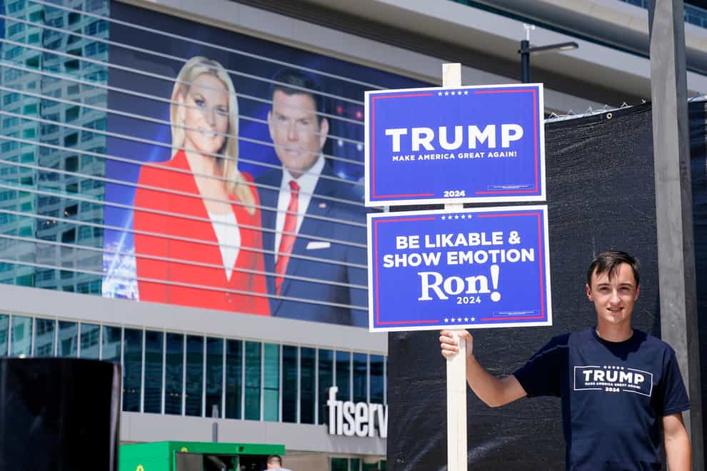 A Donald Trump supporter stands near the Fiserv Forum as set up continues for the upcoming Republican presidential debate in Milwaukee (Morry Gash, AP)