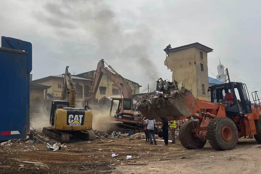 Machinery removes debris at the site of a collapsed building in Abuja, Nigeria (Chinedu Asadu/AP/PA)