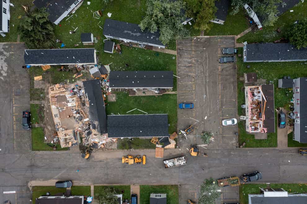 Crews clean up around devastated homes after the storm hit on Thursday night (Andy Morrison/Detroit News via AP)