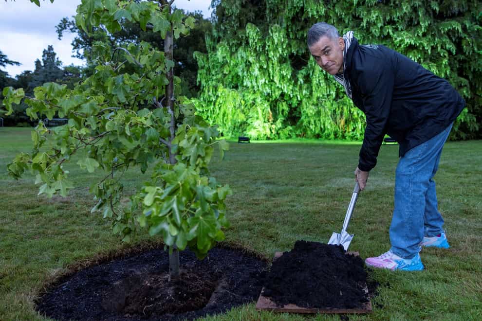 Robbie Williams plants a tree on the Sandringham Estate in Norfolk (Rupert Frere/Heritage Live)