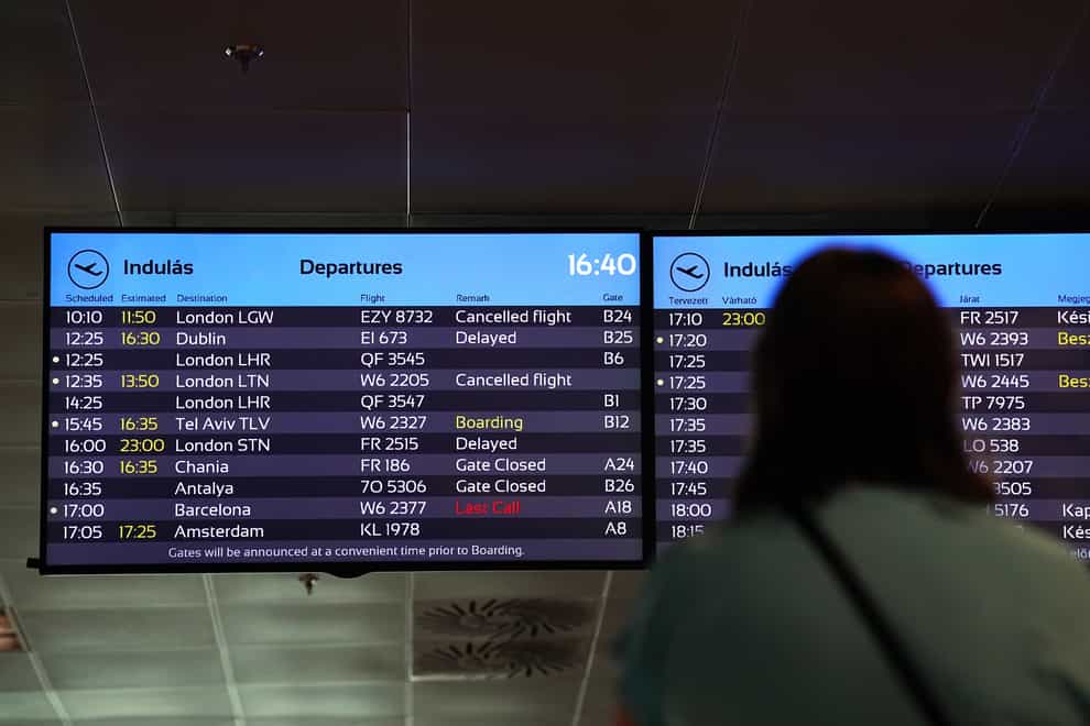 A passenger looks at a departure board at Ferenc Liszt International Airport (Martin Rickett/PA)