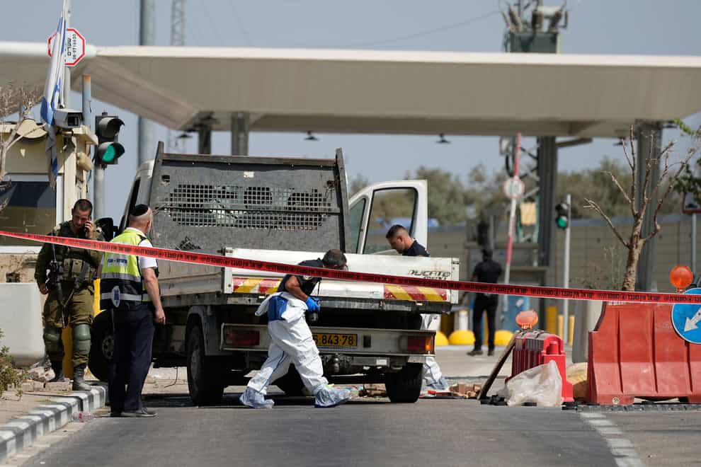 Israeli security forces inspect the scene after someone drove a truck into soldiers at a West Bank checkpoint (Ohad Zwigenberg/AP)
