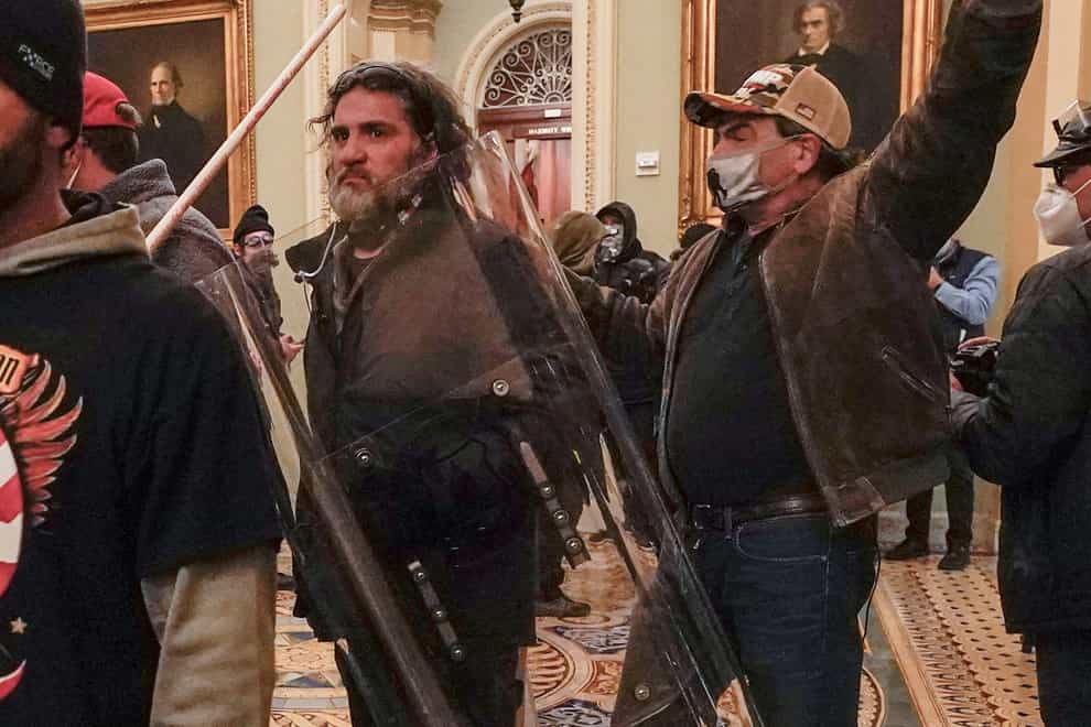 Rioters, including Dominic Pezzola, centre with police shield, are confronted by US Capitol Police officers outside the Senate Chamber inside the Capitol on January 6 2021 (Manuel Balce Ceneta/AP)