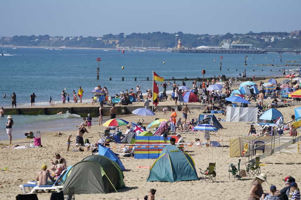 People enjoying the warm weather on Boscombe beach in Dorset (Andrew Matthews/PA)