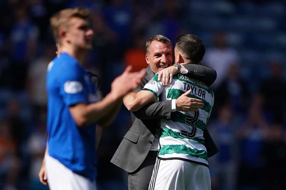 Celtic manager Brendan Rodgers celebrates with Greg Taylor after victory at Ibrox (Andrew Milligan/PA)