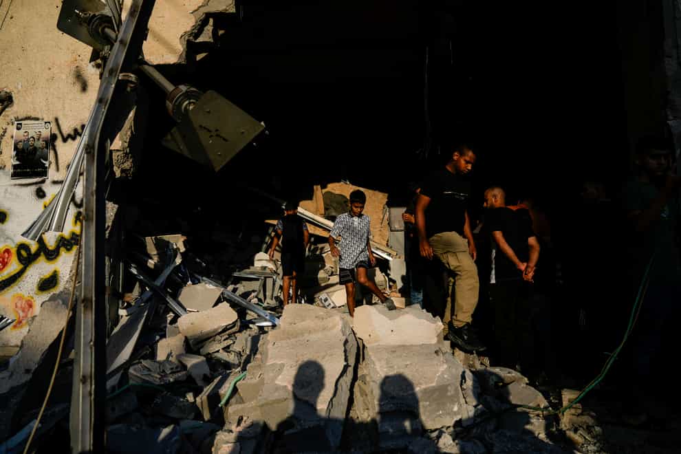 Palestinians inspect a damaged building following an Israeli army raid (Majdi Mohammed/AP)