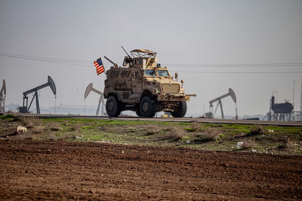 A US military vehicle drives through the countryside near the town of Qamishli, Syria (Baderkhan Ahmad/AP)
