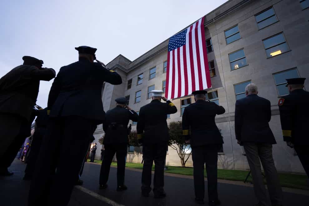 First responders salute as an American flag is unfurled at the Pentagon at sunrise to commemorate the 2001 terrorist attack on the Pentagon, during an observance ceremony in Washington, DC (AP)