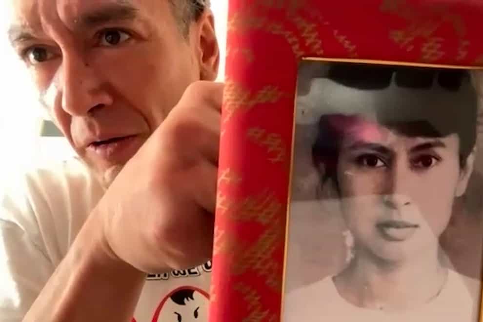 Kim Aris displaying an old family photo of his mother, Myanmar’s ousted and detained leader Aung San Suu Kyi, during an interview with The Associated Press in London (Tian Macleod Ji/AP)