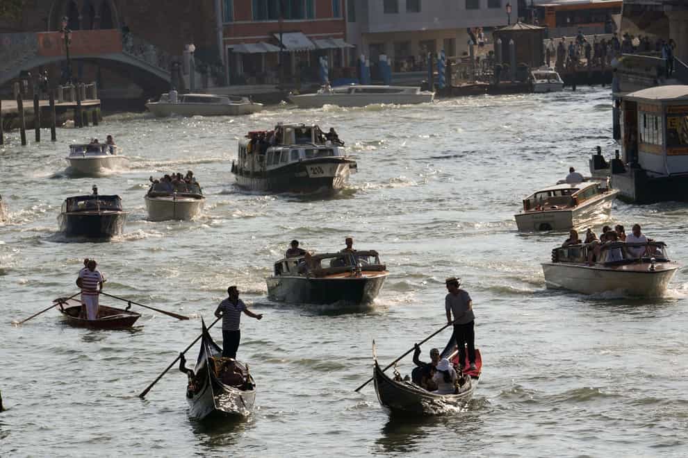 Boats and gondolas on a canal in Venice, Italy (Luca Bruno/AP)