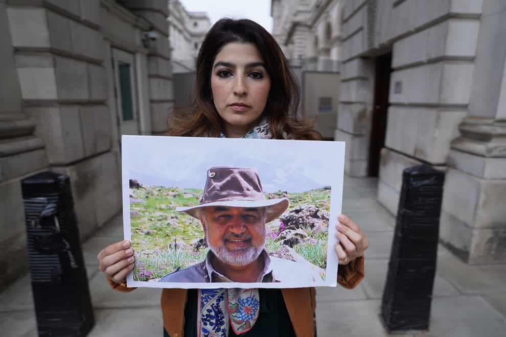 Roxanne Tahbaz holds a picture of her father Morad Tahbaz, who is jailed in Iran, during a protest outside the Foreign, Commonwealth and Development Office (Stefan Rousseau/PA)