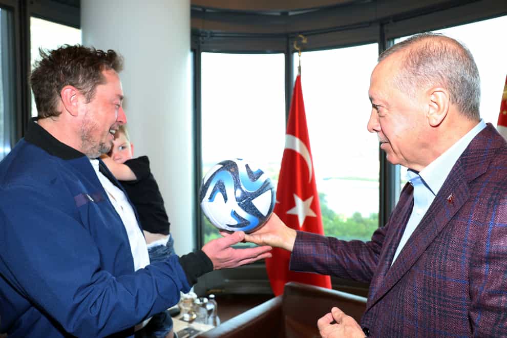 President Recep Tayyip Erdogan talks to Elon Musk, holding one of his sons, during their meeting in New York (Turkish Presidency via AP)