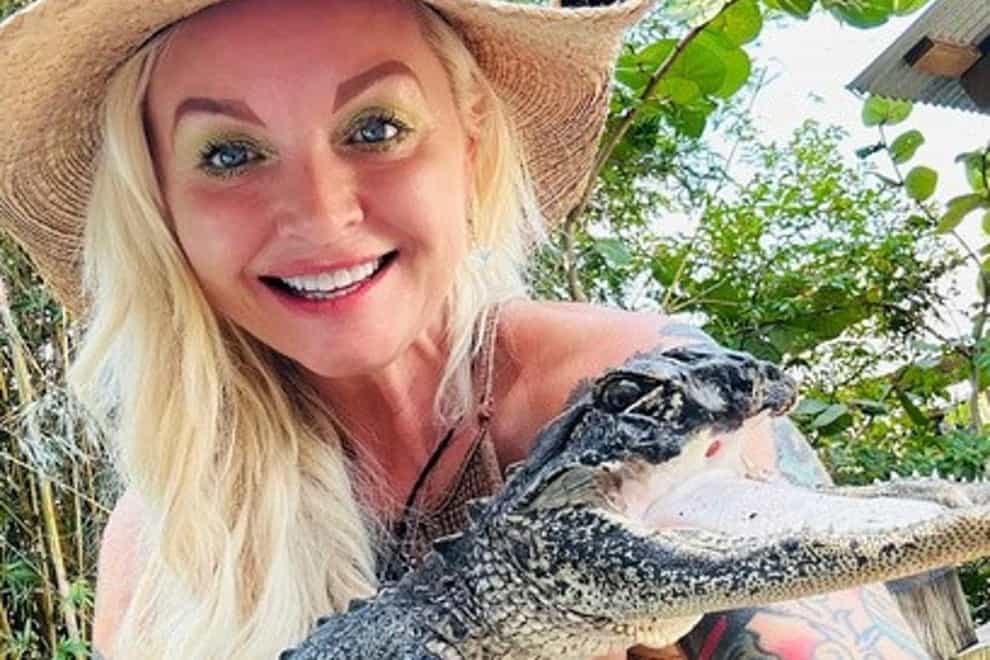 Savannah Boan, crocodilian enrichment co-ordinator at the Gatorland theme park, holds the injured reptile (Gatorland Facebook.com via AP/PA)