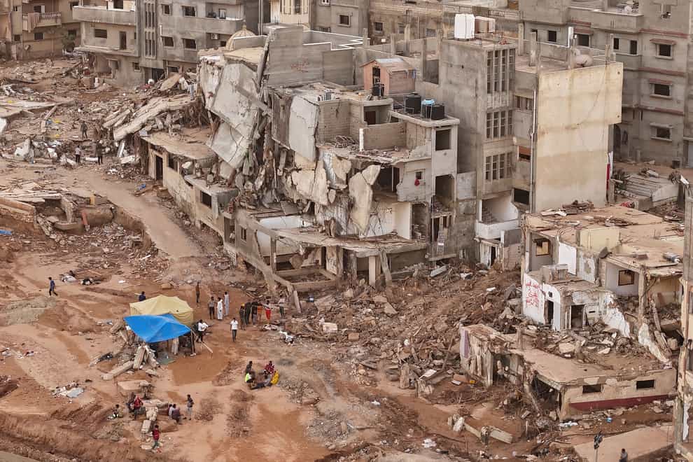 Rescuers and relatives of victims set up tents in front of collapsed buildings in Derna (Muhammad J. Elalwany/AP)
