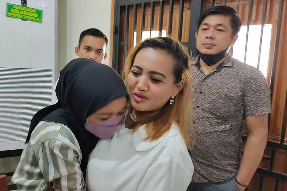 An unidentified relative hugs Lina Lutfiawati, centre, after her trial (Mohammad Fadli/AP)