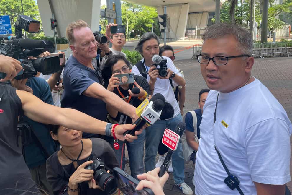 Hong Kong Journalists Association’s chairman Ronson Chan, right, speaks to reporters outside a court building in Hong Kong on Monday (Alice Fung/AP)
