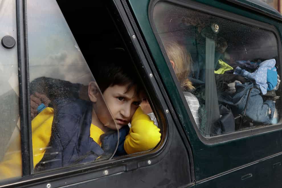An ethnic Armenian boy from Nagorno-Karabakh looks on from a car upon arrival in Armenia’s Goris (Vasily Krestyaninov/AP)
