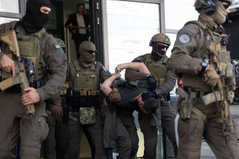 Kosovo police members of the Special Intervention Unit escort one of the arrested Serb gunmen out of court in Pristina, following a shootout at the weekend (Visar Kryeziu/AP/PA)