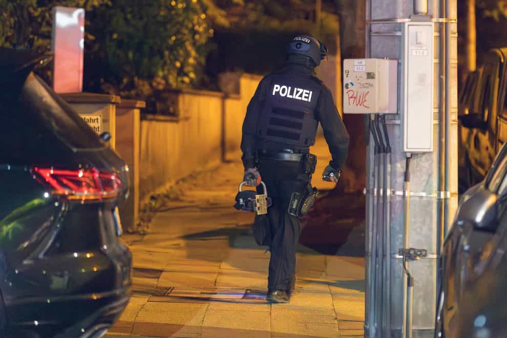 Police officers launched early-morning raids (Justin Brosch/dpa via AP)