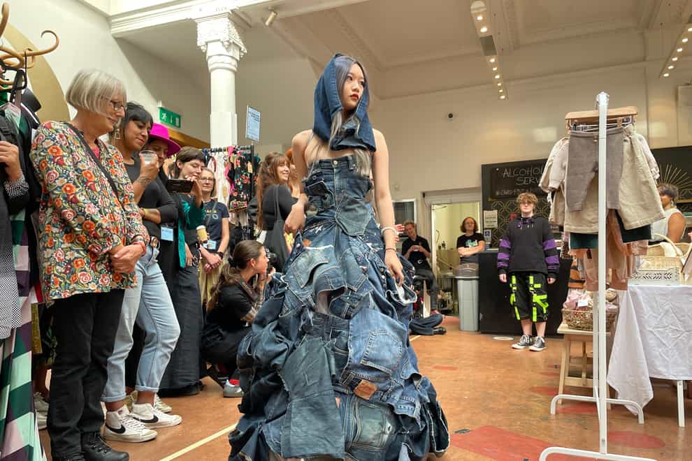 A model wearing a dress made from jeans is part of the flash mob catwalk show at Sustainable Fashion Week’s Brighton hub (PA)