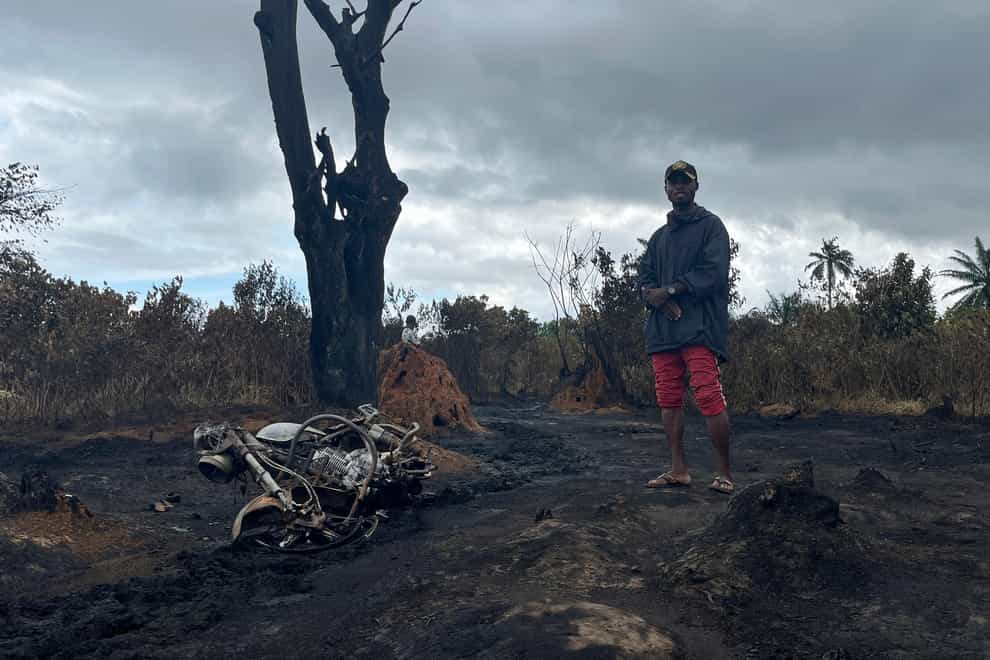A man stands at the site of an illegal refinery explosion in Emohua (AP)