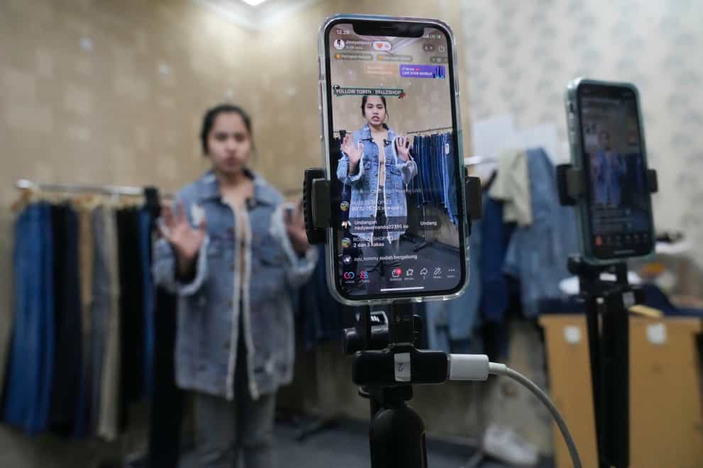 A seller offers merchandise using live streaming at a store in the Tanah Abang textile market in Jakarta (AP)