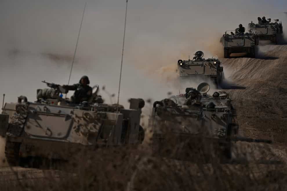 Israeli armoured personnel carriers head toward the Gaza Strip border in southern Israel on Friday (Ariel Schalit/AP/PA)