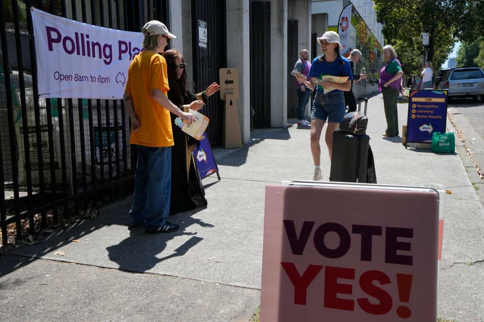 Volunteers talks with people coming to vote at a polling place in Redfern as Australians cast their final votes in Sydney (Rick Rycroft/AP)
