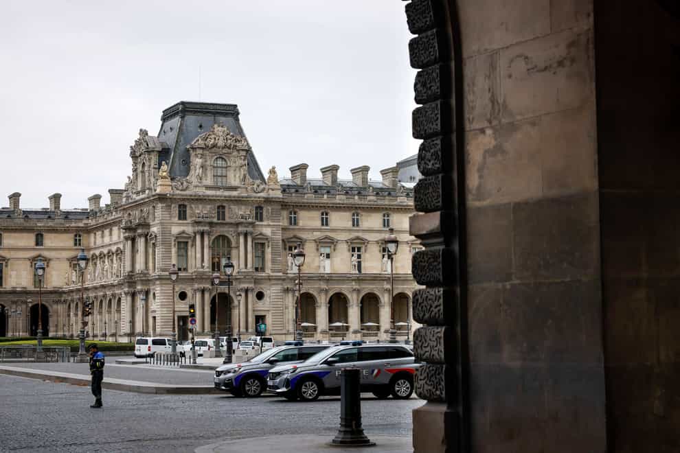 Police officers stand guard outside the Louvre Museum (AP)