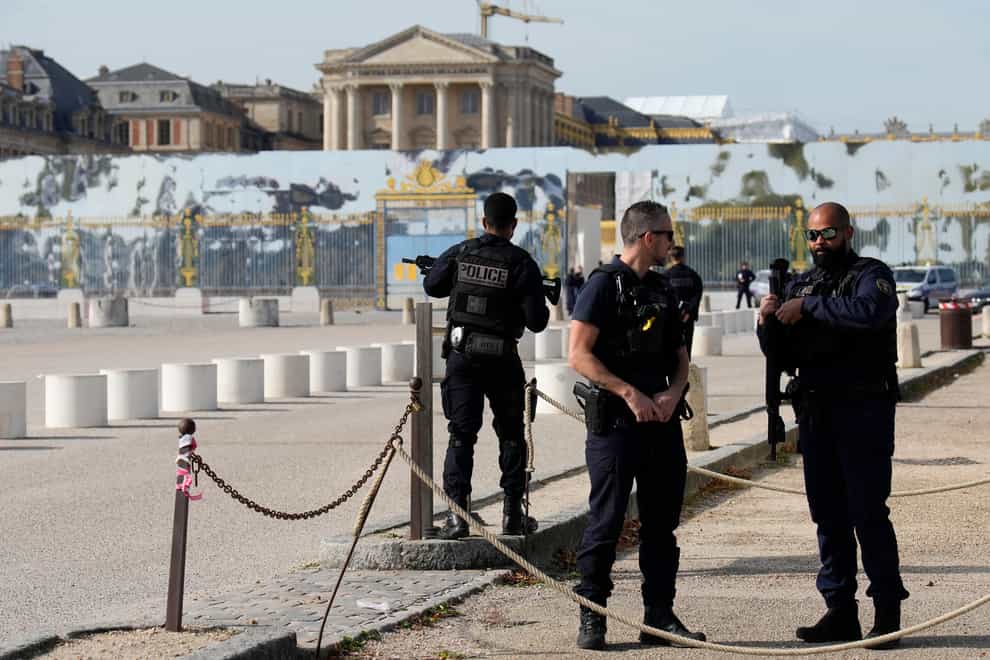 French police officers guard the entrance of the Palace of Versailles after a security alert (Christophe Ena/AP)