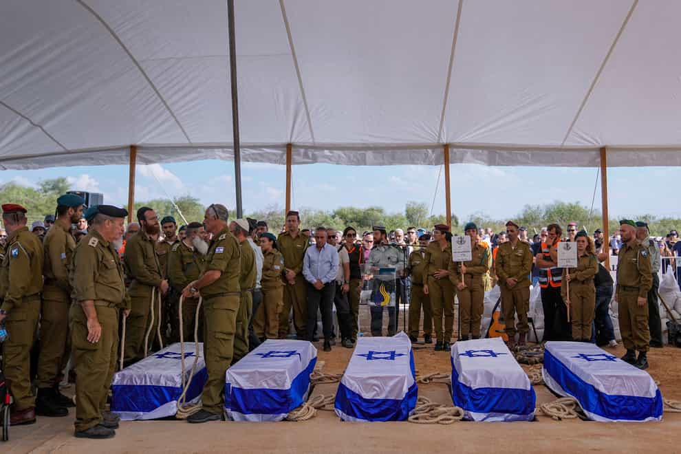 Mourners gather around the five coffins of the Kotz family (Ohad Zwigenberg/AP)