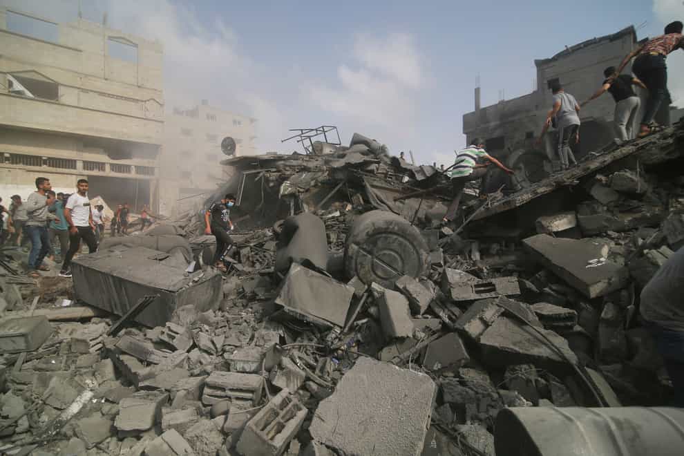 Palestinians look for survivers in buildings destroyed in the Israeli bombardment of the Gaza Strip (Hatem Ali/AP)