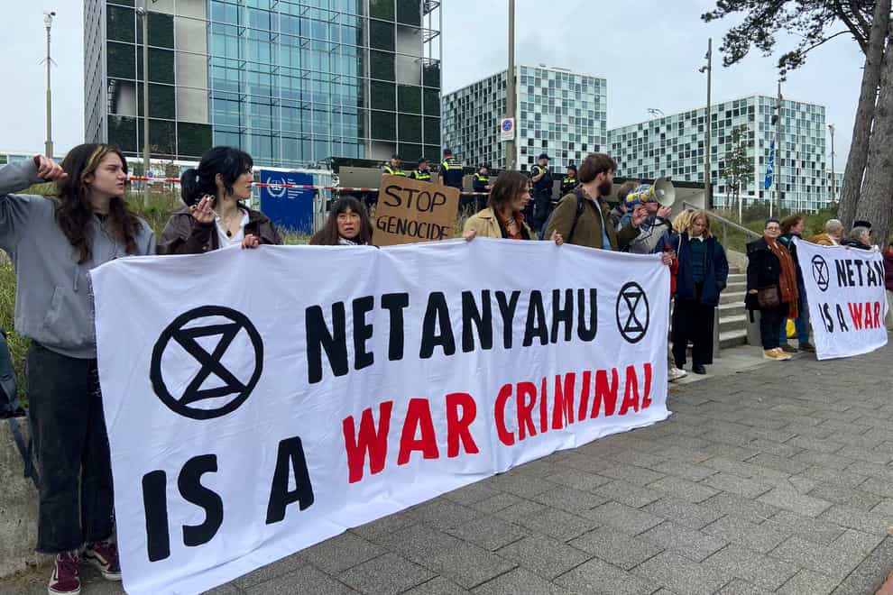 Activists hold up a banner denouncing Israeli Prime Minister Benjamin Netanyahu (Aleks Furtula/AP)