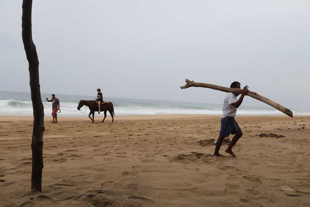 A tourist rides a horse at a beach in Acapulco (AP Photo/Bernardino Hernandez)