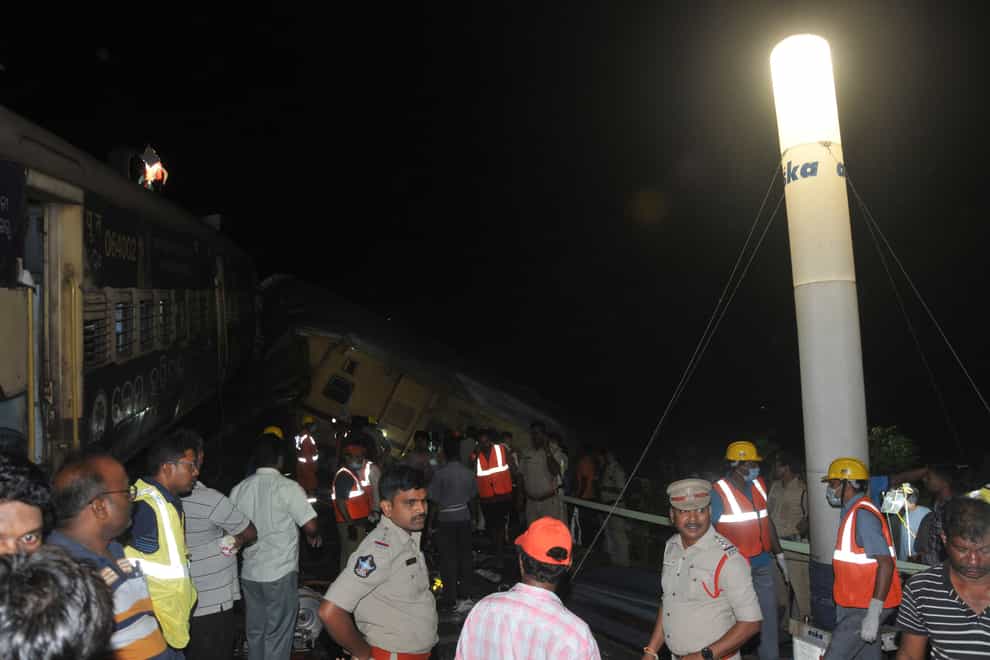 Rescuers and others stand after two passenger trains collided in Vizianagaram district (AP)