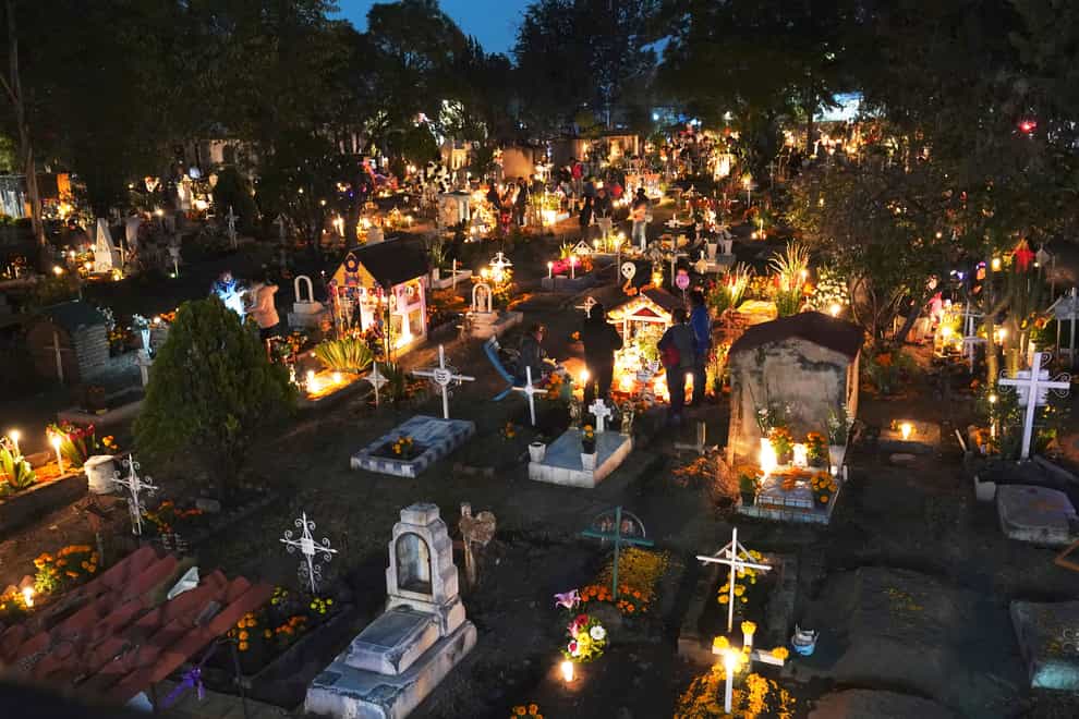 People gather in the section of children’s tombs inside the San Gregorio Atlapulco cemetery during Day of the Dead festivities on the outskirts of Mexico City, early on Wednesday (Marco Ugarte/AP)