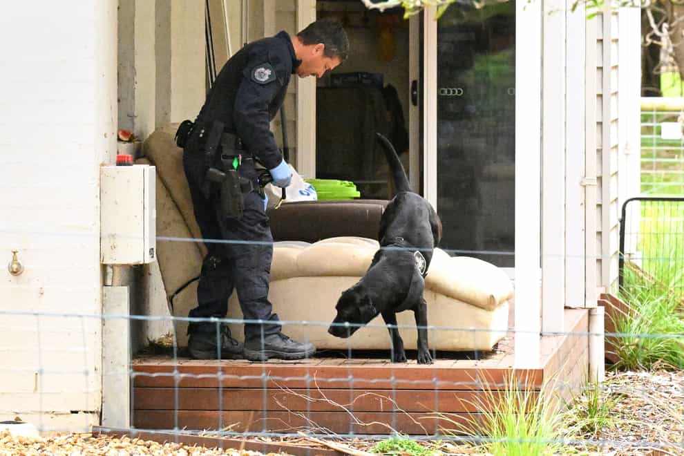 A police officer and dog investigate at the property of Erin Patterson in Leongatha, Australia (James Ross/AAP)
