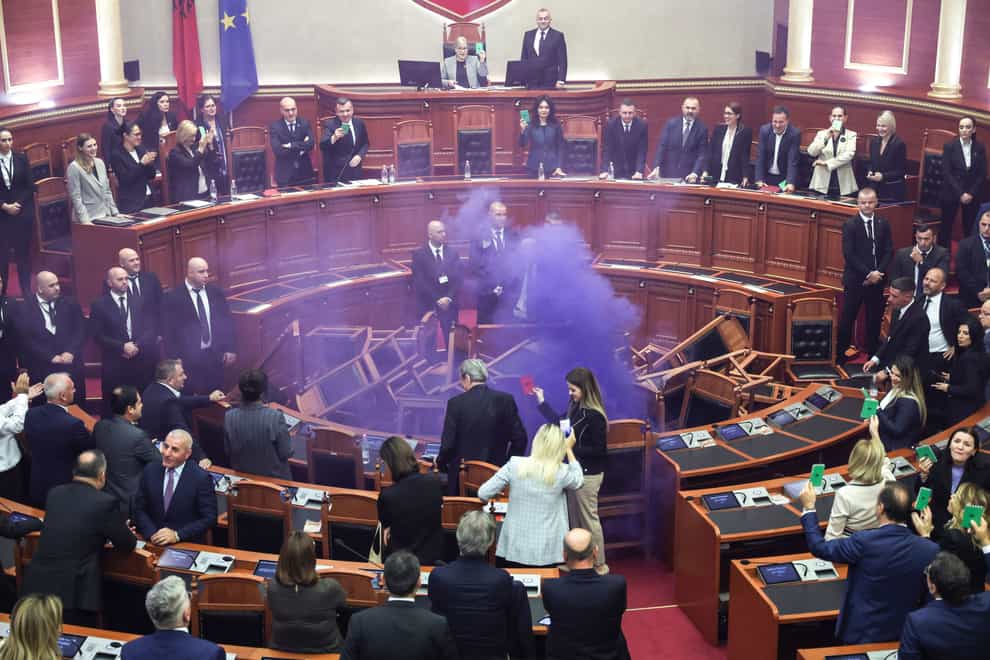 Opposition lawmakers set off a smoke bomb in the Albanian parliament as part of a protest (AP Photo)