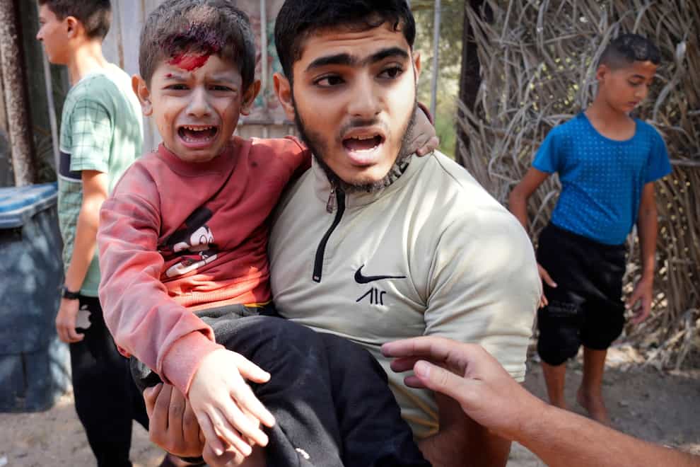 A wounded boy is carried after an Israeli strike in Deir Al-Balah, southern Gaza Strip, on Thursday (Hatem Moussa/AP)