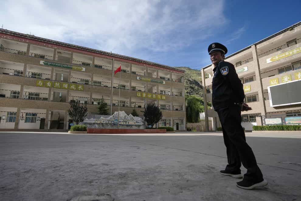 A security guard stands watch at the Shangri-La Key boarding school in Sichuan province, China (AP Photo/Andy Wong)