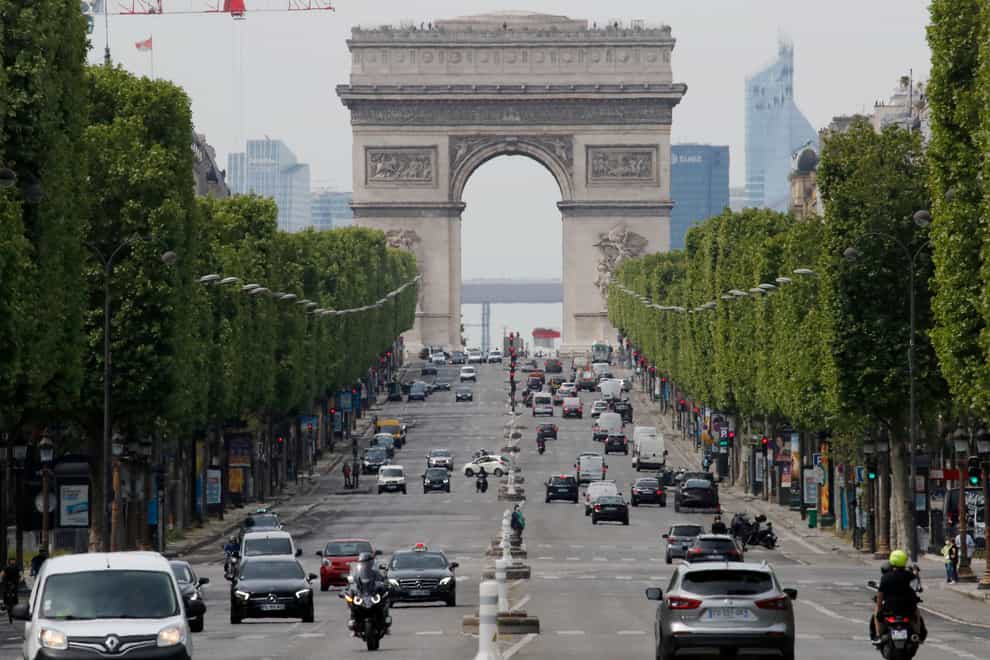 Cars drive on the Champs Elysee avenue in Paris (Christophe Ena/AP)
