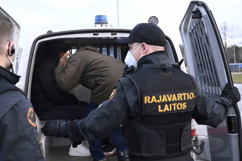 Migrants arriving from Russia board a van to be taken to the Joutseno Reception Centre at the Nuijamaa border station between Russia and Finland (Vesa Moilanen/Lehtikuva via AP)