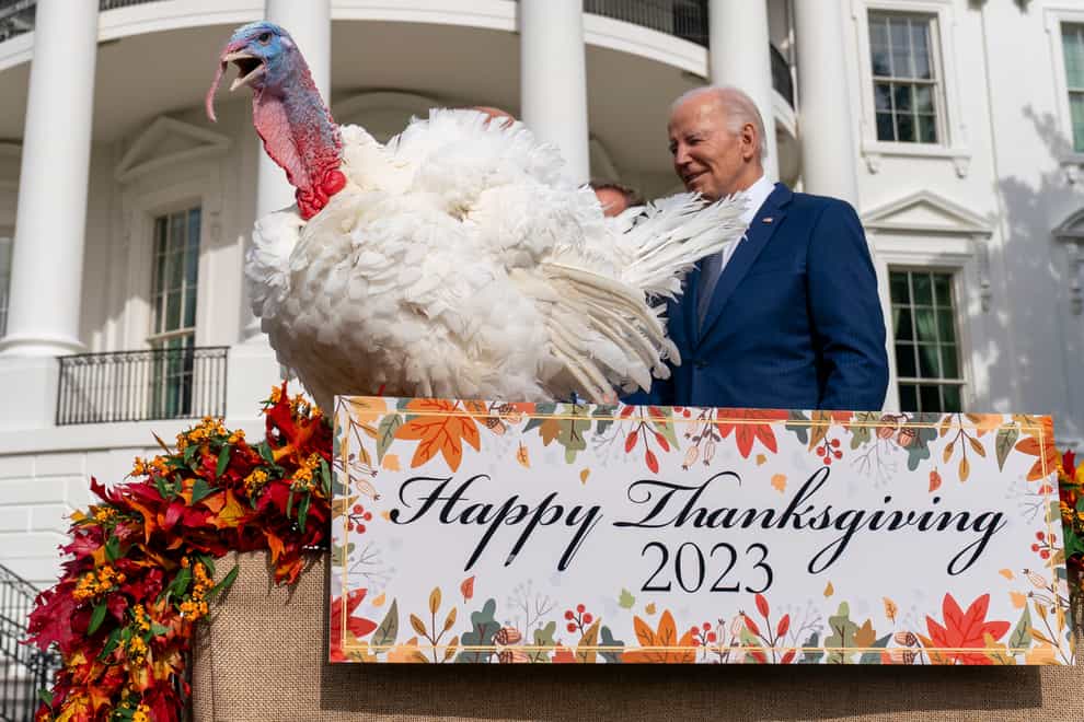President Joe Biden stands next to Liberty, one of the two national Thanksgiving turkeys, after pardoning them during a ceremony on the South Lawn of the White House (AP Photo/Andrew Harnik)